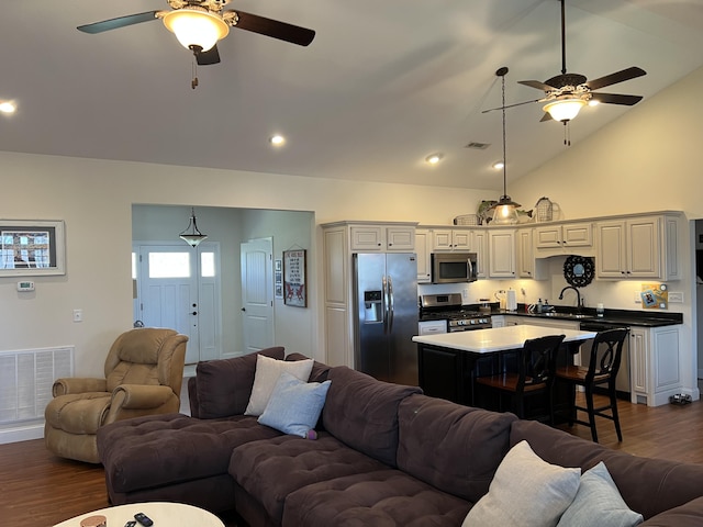 living area featuring visible vents, dark wood-style floors, and a ceiling fan