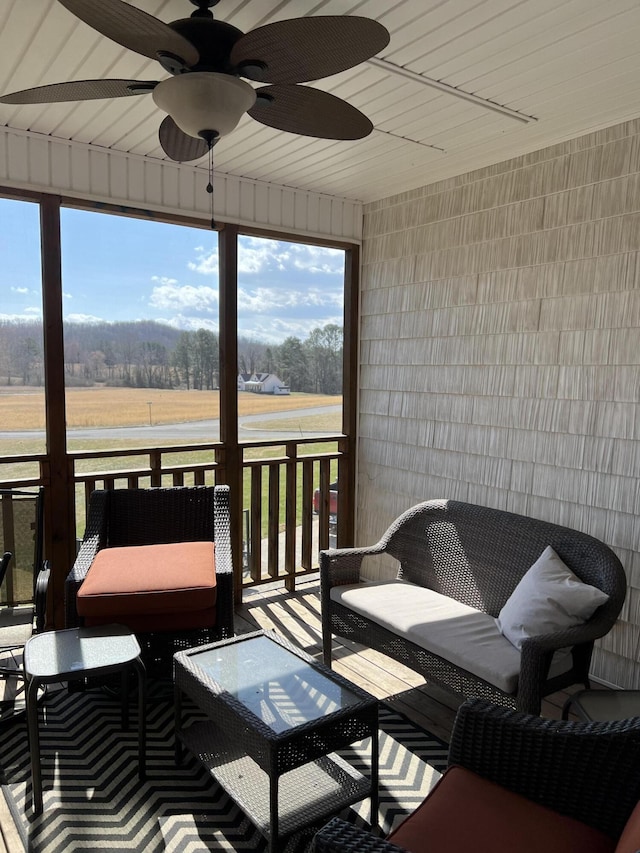 sunroom / solarium featuring a ceiling fan