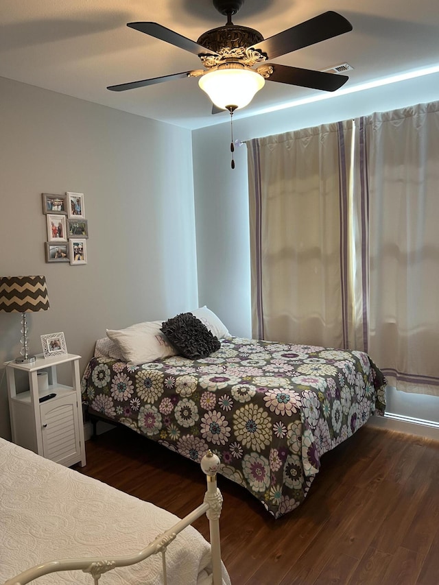 bedroom with dark wood finished floors, visible vents, and ceiling fan