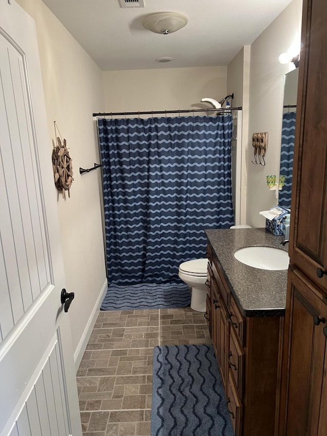 bathroom with a shower with curtain, toilet, brick floor, baseboards, and vanity