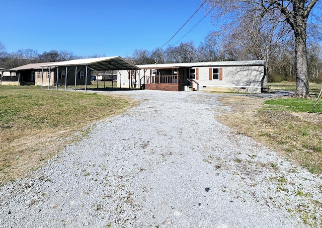 manufactured / mobile home with gravel driveway, a front lawn, covered porch, and crawl space