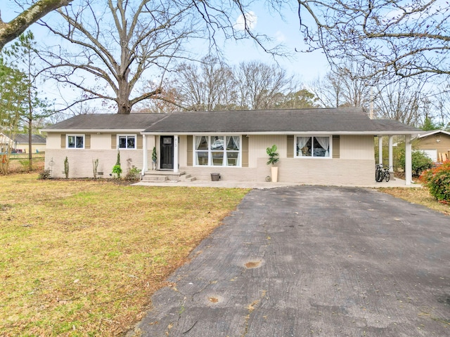 ranch-style home with brick siding, driveway, and a front lawn