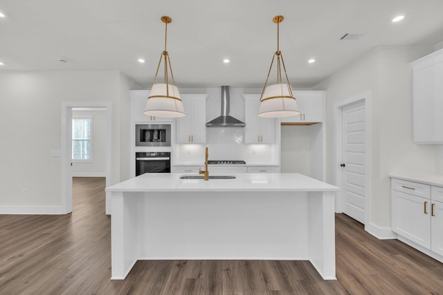 kitchen with black appliances, wall chimney range hood, recessed lighting, and a sink