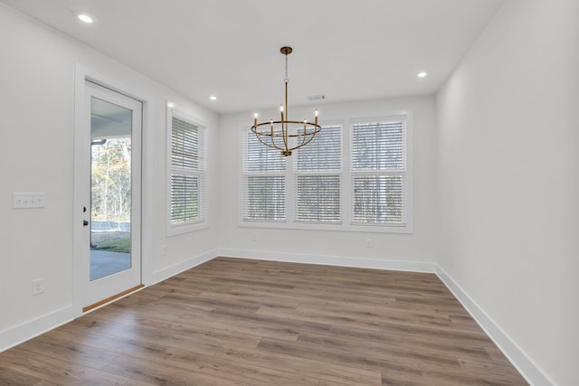 unfurnished dining area with a wealth of natural light, baseboards, wood finished floors, and recessed lighting