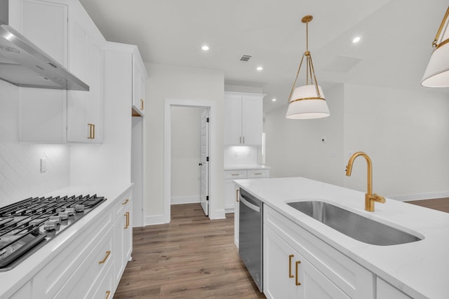 kitchen with visible vents, appliances with stainless steel finishes, dark wood-style floors, wall chimney exhaust hood, and a sink