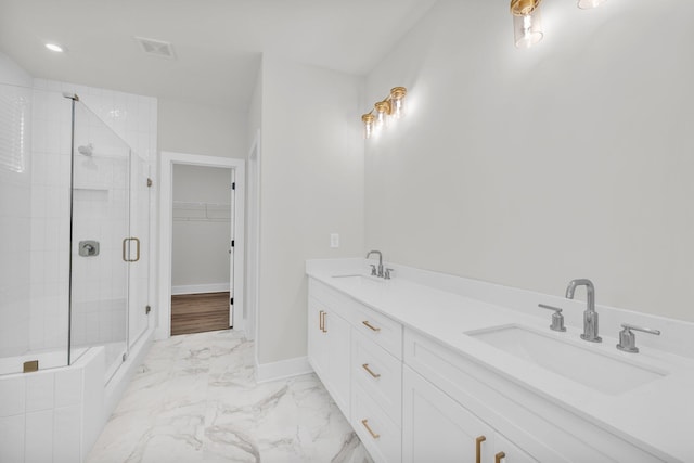 bathroom with visible vents, a walk in closet, a stall shower, marble finish floor, and a sink