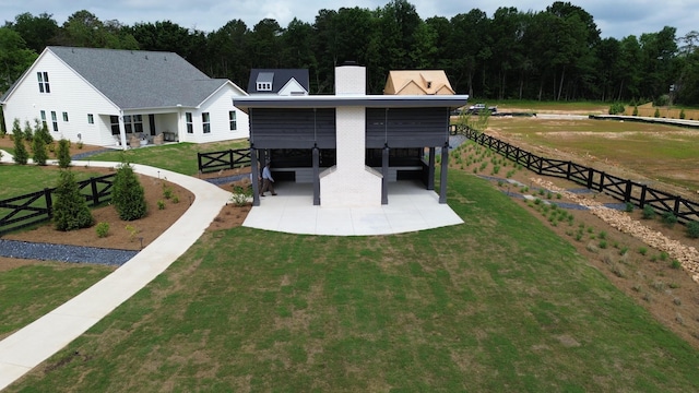 rear view of property featuring a lawn, a chimney, and fence