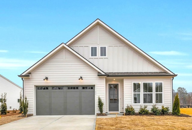 view of front of home with concrete driveway, an attached garage, board and batten siding, and a front yard