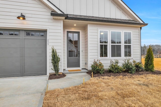 doorway to property featuring an attached garage and board and batten siding