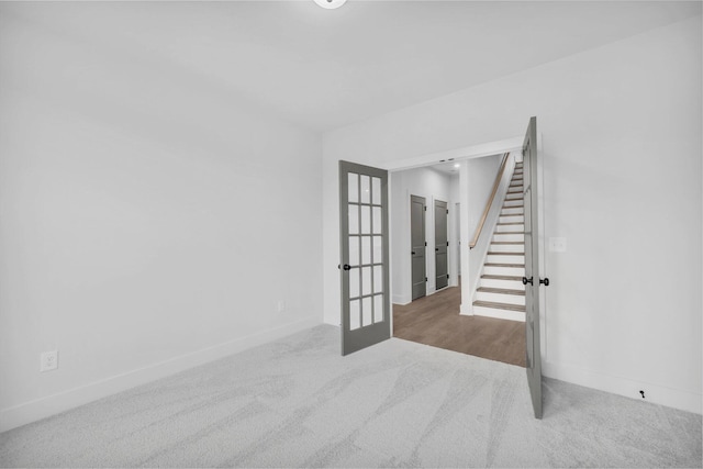 interior space featuring french doors, baseboards, carpet flooring, and stairs