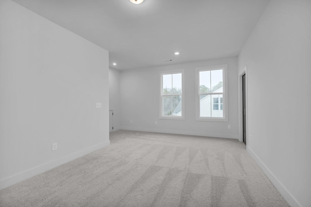 empty room with recessed lighting, baseboards, and light carpet