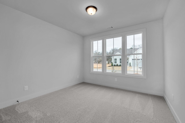 unfurnished room with visible vents, baseboards, and carpet flooring