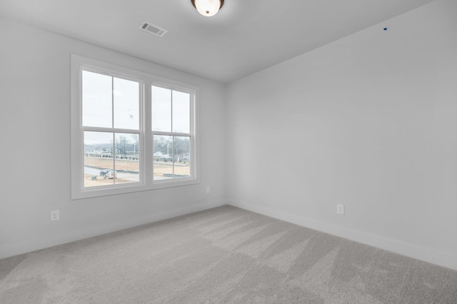 empty room featuring visible vents, carpet floors, and baseboards