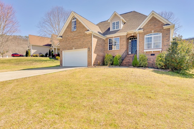 view of front of house featuring a front yard, an attached garage, brick siding, and driveway