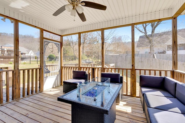 sunroom / solarium with a residential view and ceiling fan