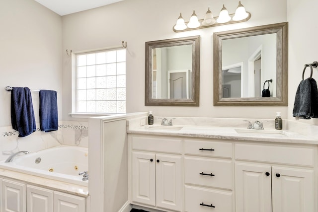 full bathroom featuring double vanity, a whirlpool tub, and a sink