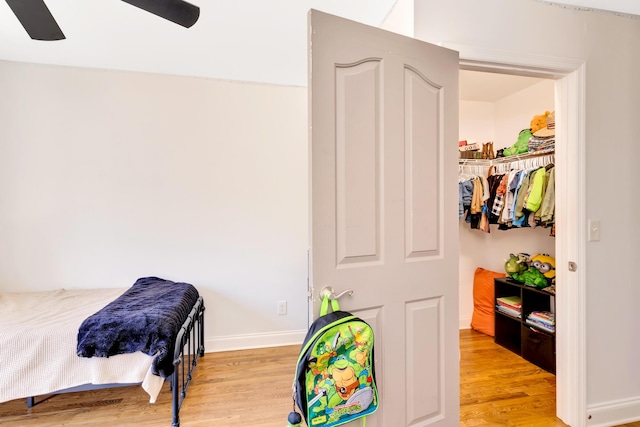 bedroom with ceiling fan, baseboards, and light wood-style flooring