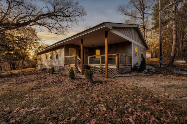 property exterior at dusk featuring a porch