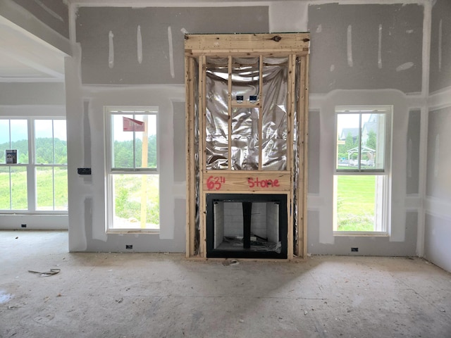 unfurnished living room featuring a glass covered fireplace
