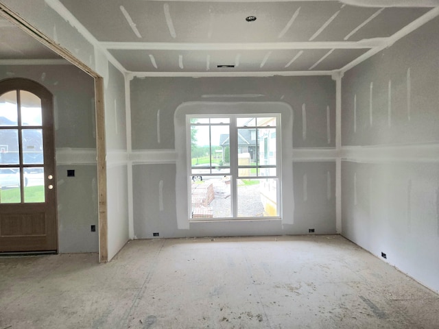 empty room with arched walkways and plenty of natural light