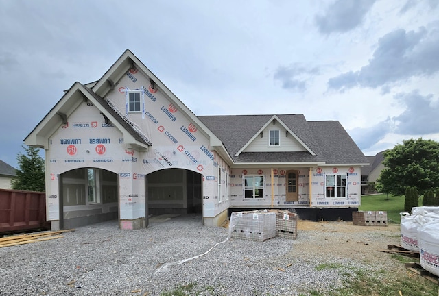 unfinished property with a shingled roof and a porch