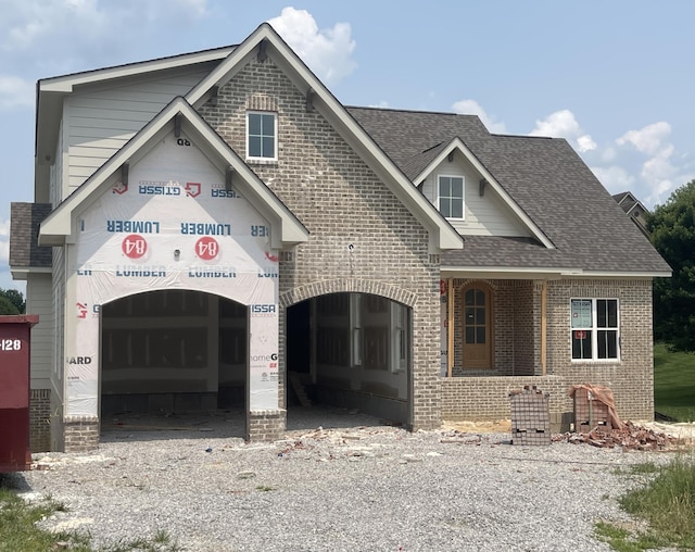 12800 Blakeslee Dr Unit 22, Soddy Daisy, TN 37379 - view of front of house featuring brick siding, roof with shingles, gravel driveway, an attached garage, and a porch