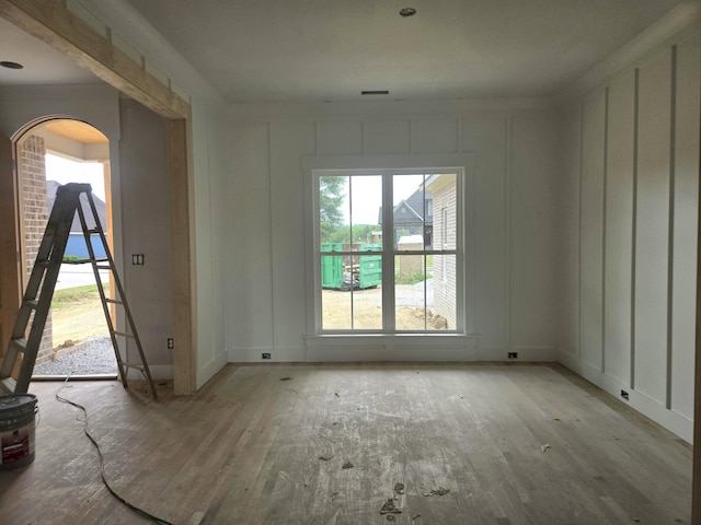 12800 Blakeslee Dr Unit 22, Soddy Daisy, TN 37379 - unfurnished room with arched walkways, a decorative wall, and wood finished floors