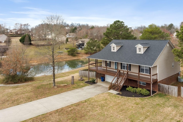 back of house with a water view, a porch, concrete driveway, stairs, and a lawn