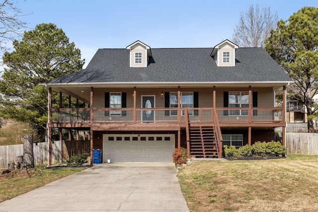 view of front of house with a front yard, fence, an attached garage, stairs, and concrete driveway