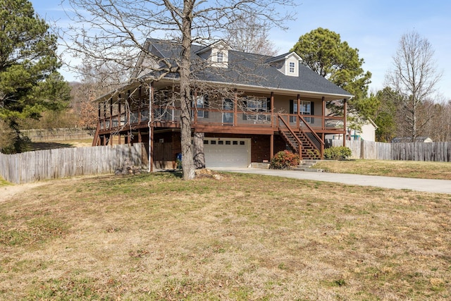 view of front facade with stairway, fence, driveway, a front lawn, and a garage