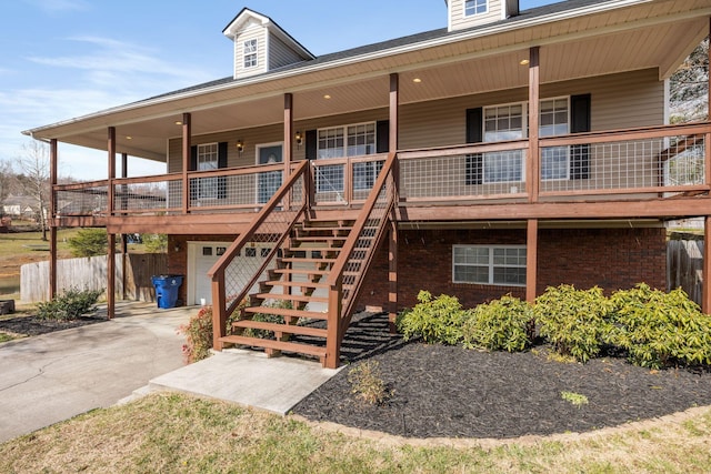 view of property with stairway, an attached garage, and concrete driveway