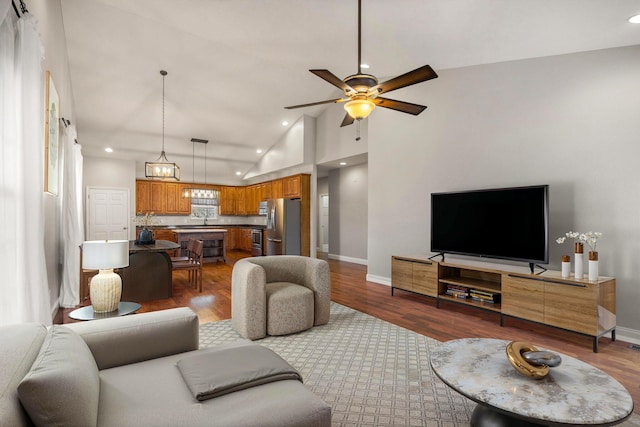 living room with a ceiling fan, baseboards, and wood finished floors