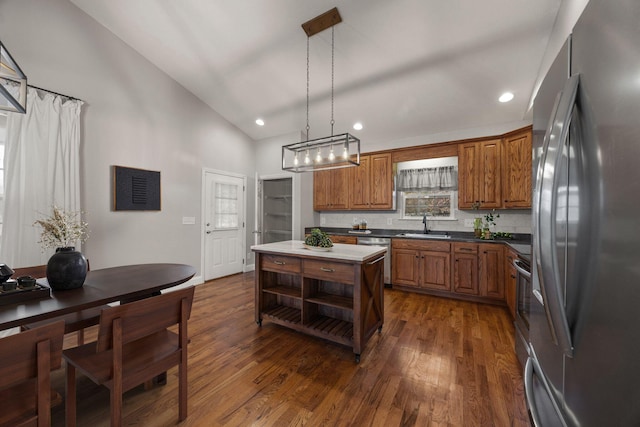 kitchen featuring brown cabinets, stainless steel appliances, dark wood-type flooring, and a sink