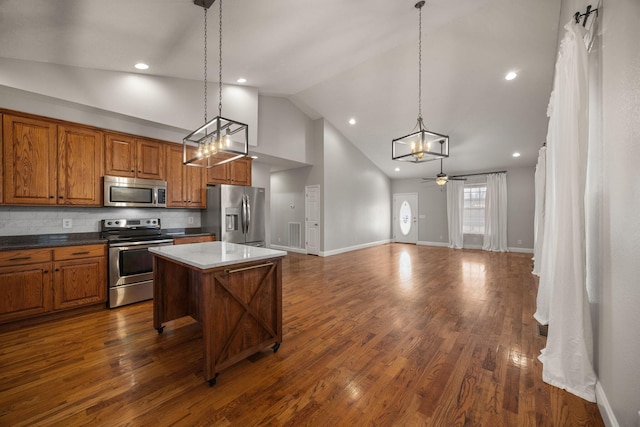 kitchen featuring brown cabinets, stainless steel appliances, ceiling fan, and dark wood-style flooring