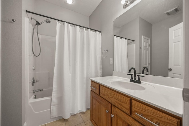 bathroom featuring visible vents, shower / bathtub combination with curtain, a textured ceiling, tile patterned flooring, and vanity