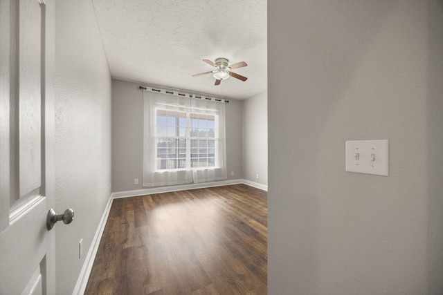 empty room with baseboards, a textured ceiling, wood finished floors, and a ceiling fan