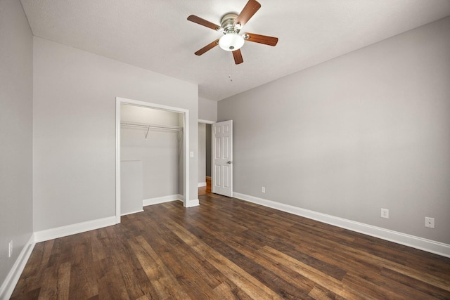 unfurnished bedroom featuring baseboards, dark wood-style flooring, and a closet