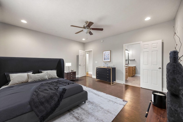 bedroom featuring recessed lighting, ensuite bath, baseboards, and wood finished floors