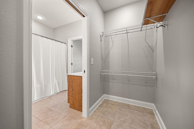 spacious closet featuring light tile patterned floors