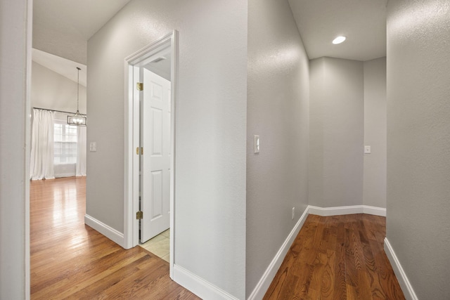 corridor with wood finished floors and baseboards