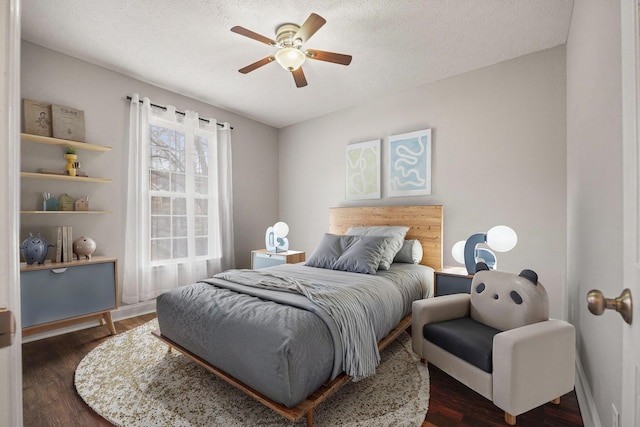 bedroom with a textured ceiling, ceiling fan, and dark wood-style flooring