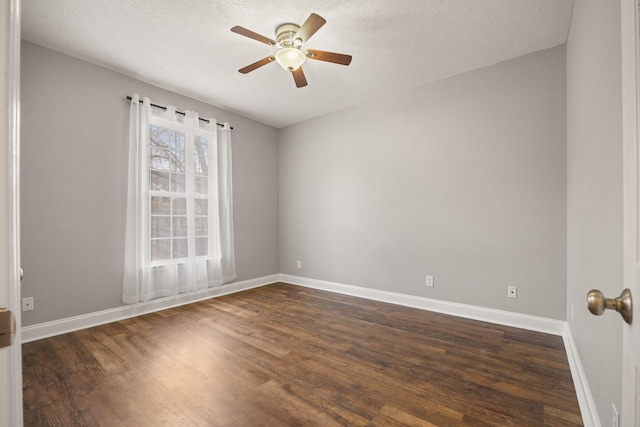 empty room featuring ceiling fan, baseboards, and dark wood-style floors