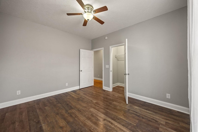 unfurnished bedroom featuring baseboards, dark wood-style flooring, a closet, and a textured ceiling