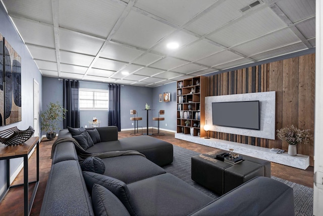 living area featuring wood finished floors, built in shelves, baseboards, and visible vents