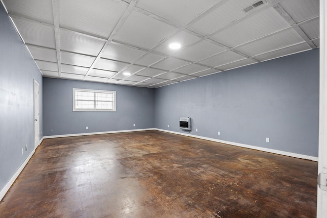 basement featuring heating unit, baseboards, and visible vents