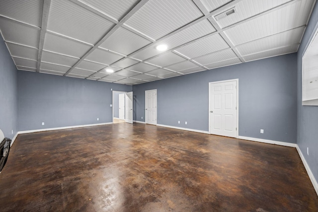 spare room featuring visible vents, baseboards, and concrete flooring