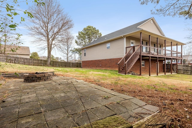 back of property with a fenced backyard, stairway, a yard, a fire pit, and a patio area