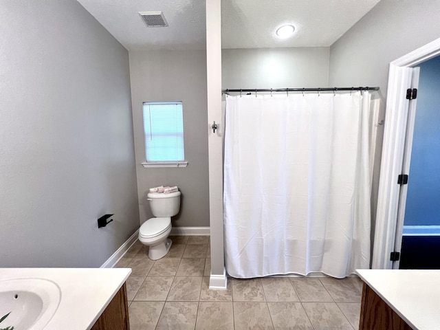 bathroom featuring visible vents, toilet, a textured ceiling, baseboards, and vanity