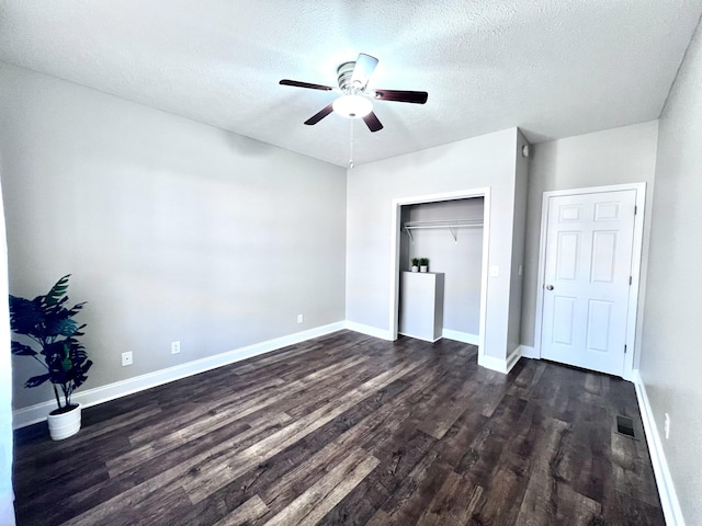 unfurnished bedroom with visible vents, baseboards, a textured ceiling, and dark wood finished floors