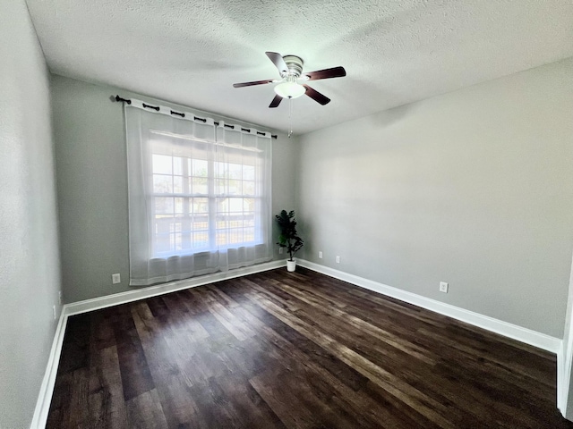 unfurnished room featuring dark wood-style floors, baseboards, and a textured ceiling